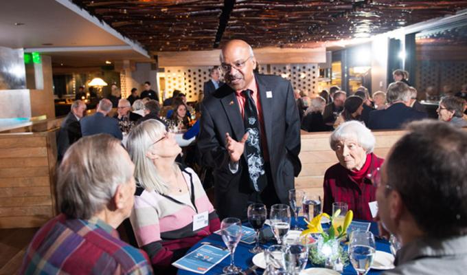 Sastry talking to table of colleagues