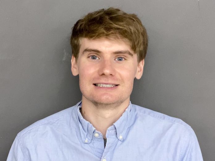 Headshot of Nick Marshall standing in front of a gray wall