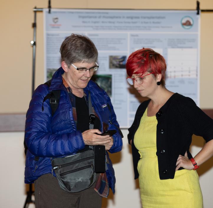 Heidi M. Schellman and Gabs James chatting next to research posters